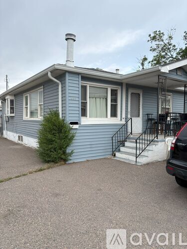 A blue house with a white car parked in front.