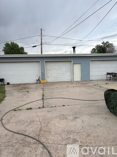 A grey building with a white garage door is in the image.