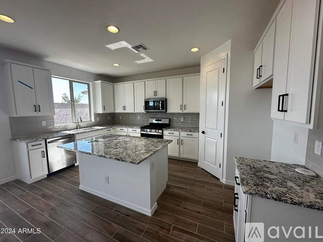 A kitchen with granite countertops and white cabinets.