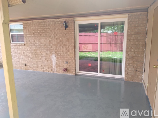 A room with a sliding glass door leading to a backyard.
