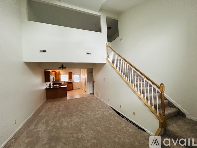 A spacious living room with a staircase leading to the upper floor.