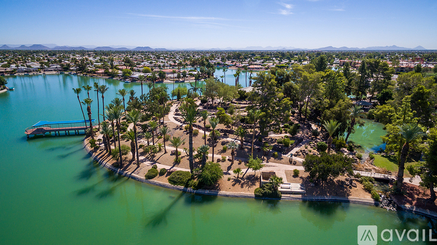 A bird's eye view of a resort with a lake and palm trees.