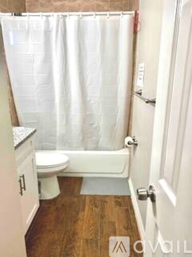 A white toilet sits next to a bathtub in a bathroom.