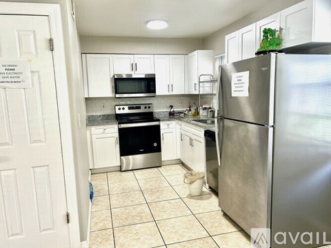 A kitchen with a refrigerator, stove, and microwave.