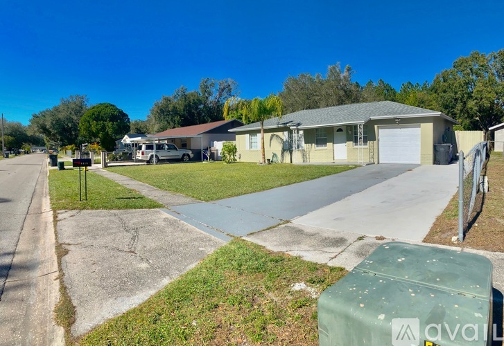 A sunny day in a residential area with houses and a clear blue sky.