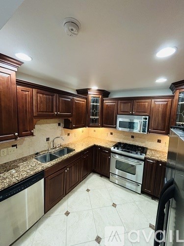 A kitchen with wooden cabinets and granite countertops.