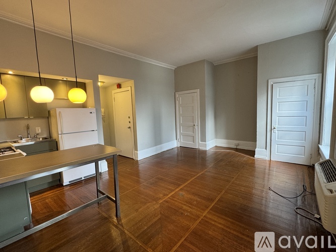 A kitchen with a wooden floor and a white refrigerator.