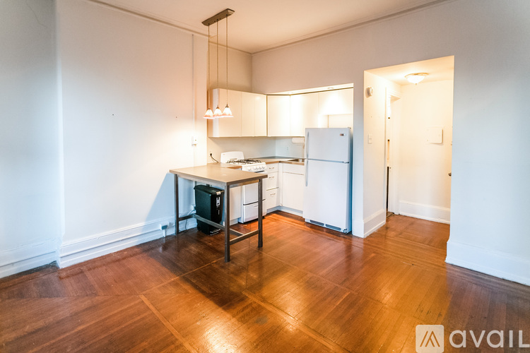 A kitchen with wooden floors and white walls.
