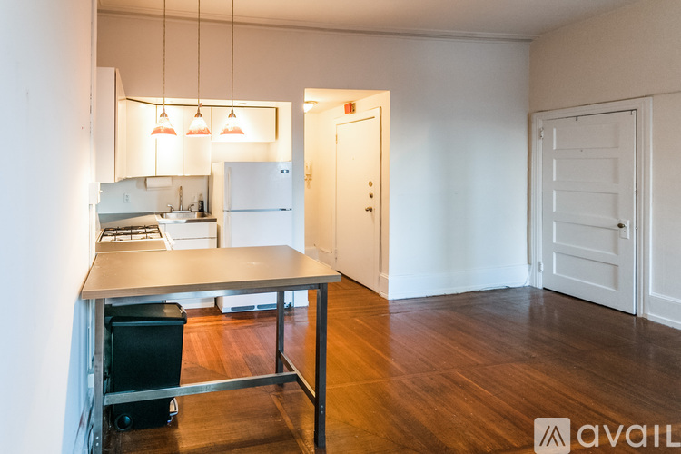 A kitchen area with a table and chairs in a room with white walls.