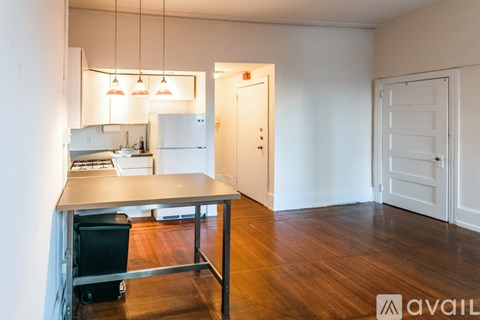 A kitchen area with a table and chairs in a room with white walls.