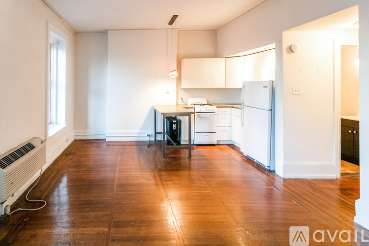 A kitchen with wooden floors and white walls.