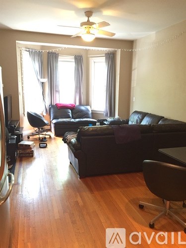 A living room with a black couch and a television.