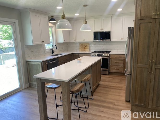 A kitchen with a white countertop and wooden cabinets.