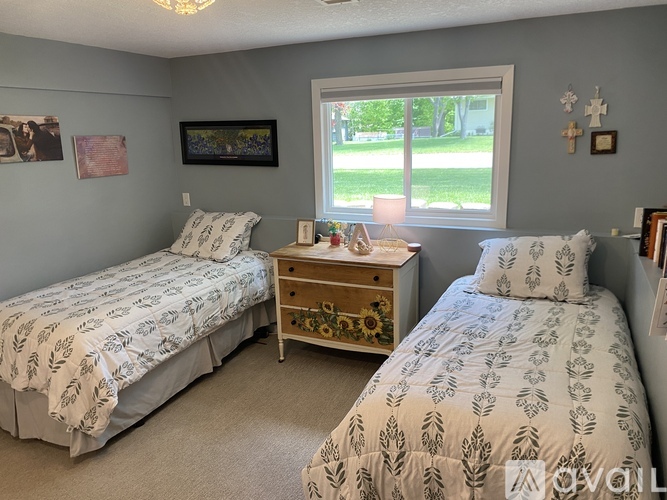 A bedroom with two beds and a dresser.