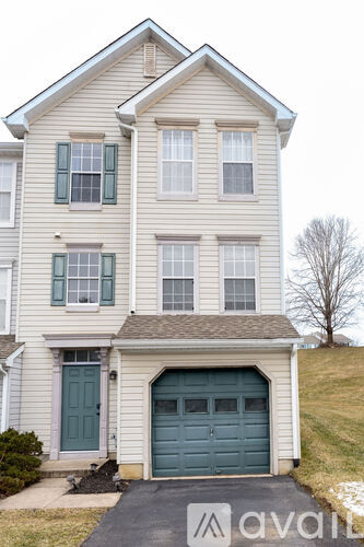 A two-story house with a garage and a driveway.
