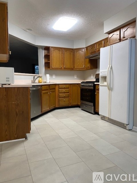 A kitchen with wooden cabinets and a white refrigerator.