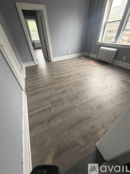 A room with wooden flooring and a window.