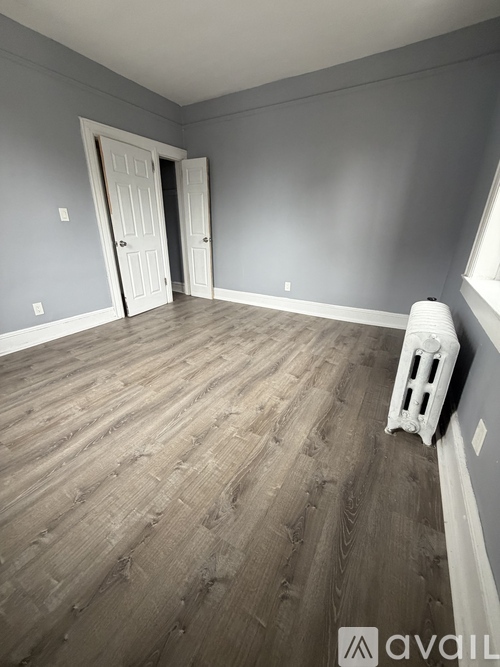 A room with wooden flooring and two doors.