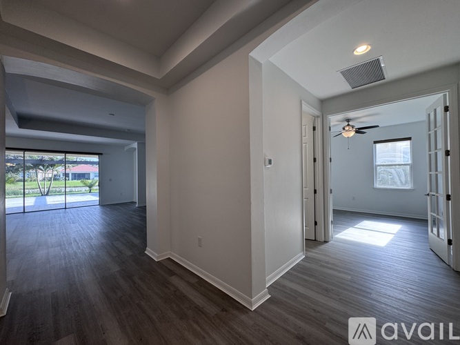 A spacious room with wood flooring and a ceiling fan.