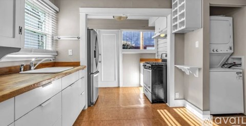A kitchen with white cabinets and a wooden countertop.