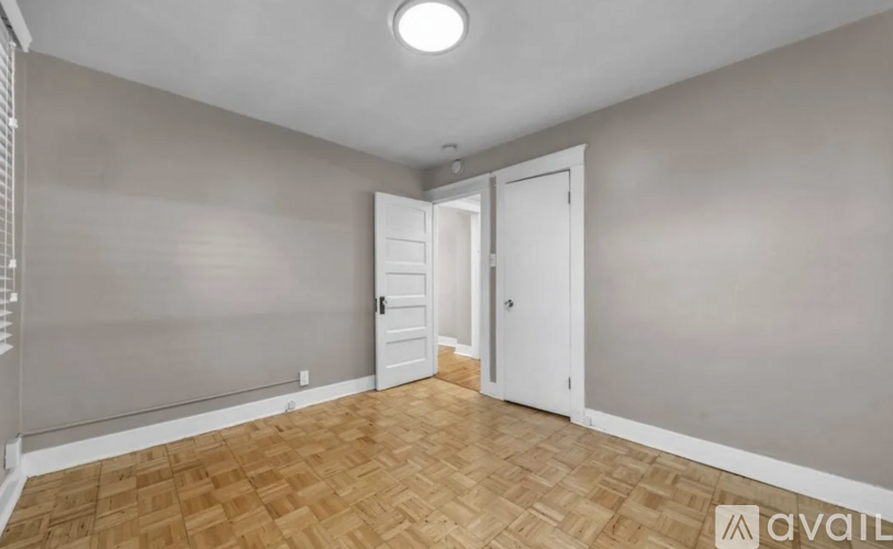 A room with wooden flooring and white walls.