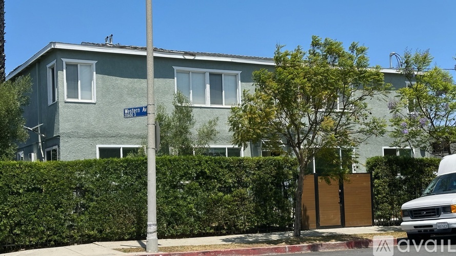 A grey house with a white van parked in front.