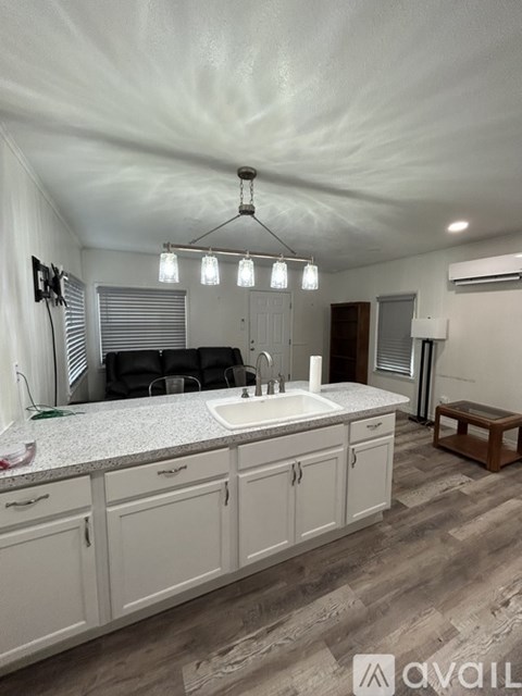 A kitchen with white cabinets and a granite countertop.
