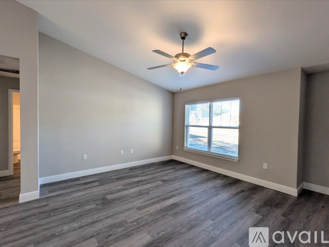 A spacious room with a ceiling fan and a window.