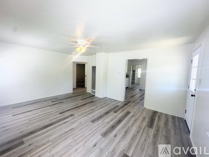 A room with wooden flooring and white walls.