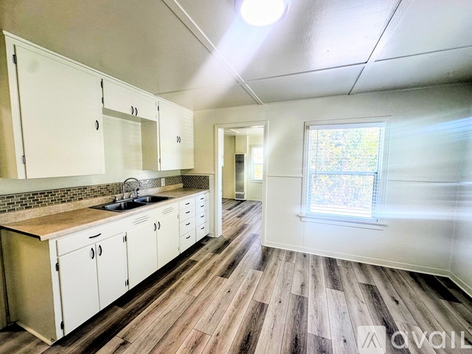 A kitchen with white cabinets and a wooden countertop.