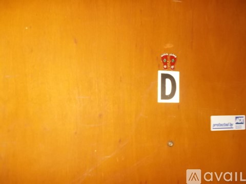 A wooden door with a sticker that says "available" and a letter "D" with a crown above it.