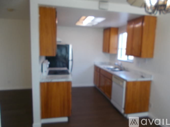 A kitchen with wooden cabinets and a black fridge.