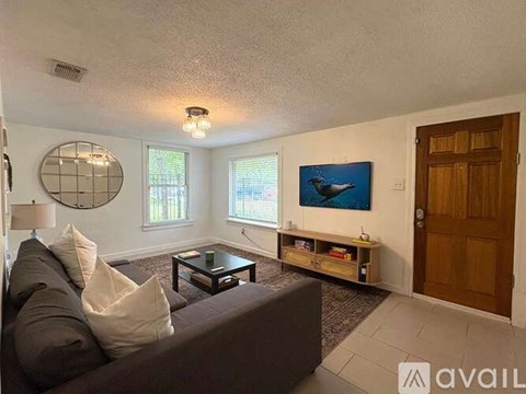 A living room with a couch, a coffee table, and a painting on the wall.