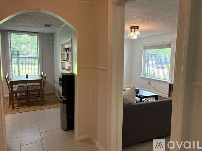 A bedroom with a bed and a window with a view of a fence and trees.