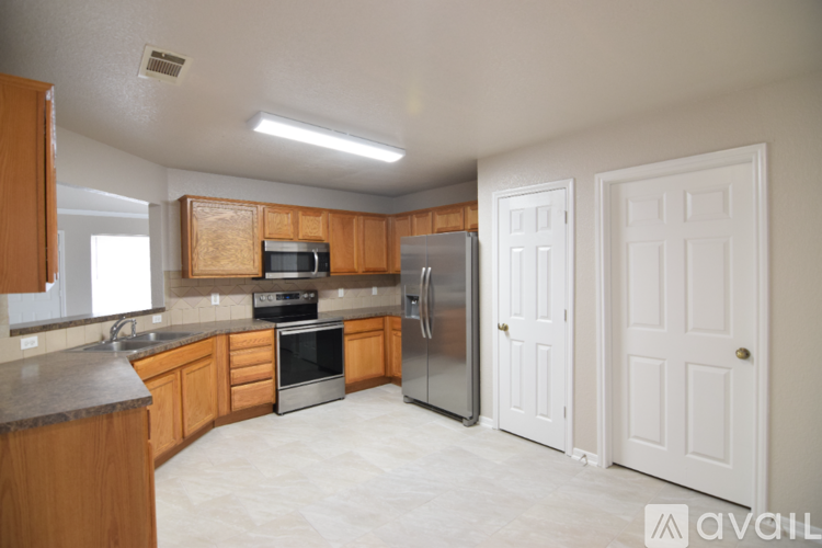 A kitchen with wooden cabinets and a refrigerator.