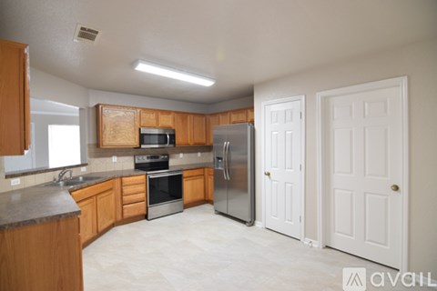 A kitchen with wooden cabinets and a refrigerator.