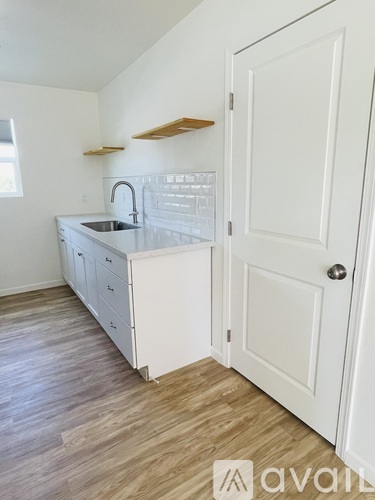 A kitchen with white cabinets and a sink.