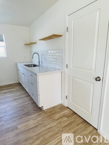 A kitchen with white cabinets and a sink.
