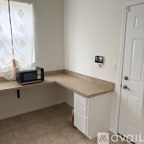 A kitchen counter with a microwave on it.