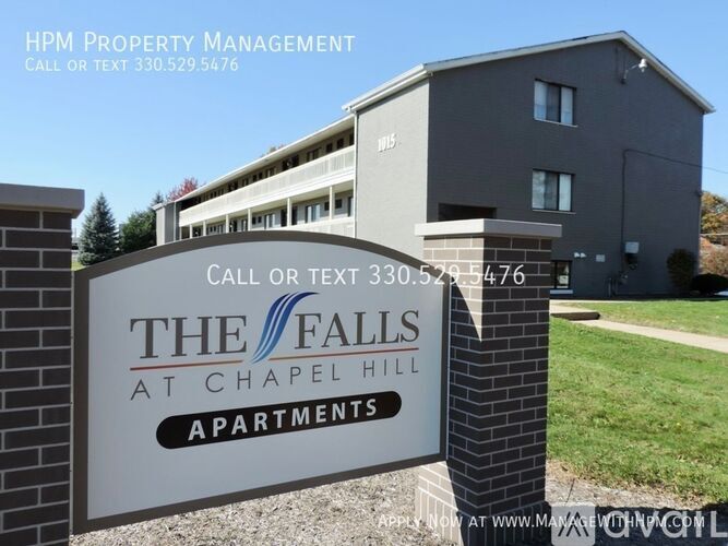 A sign for The Falls at Chapel Hill Apartments with a phone number and website for HPM Property Management.