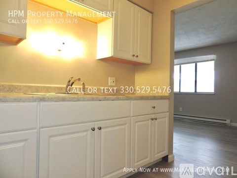 A kitchen with white cabinets and a countertop with a sink.