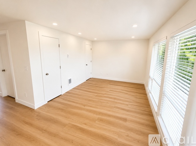 A room with wooden flooring and white walls.