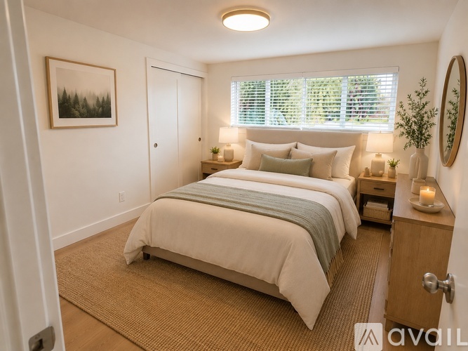 A bedroom with a large bed and a painting on the wall.