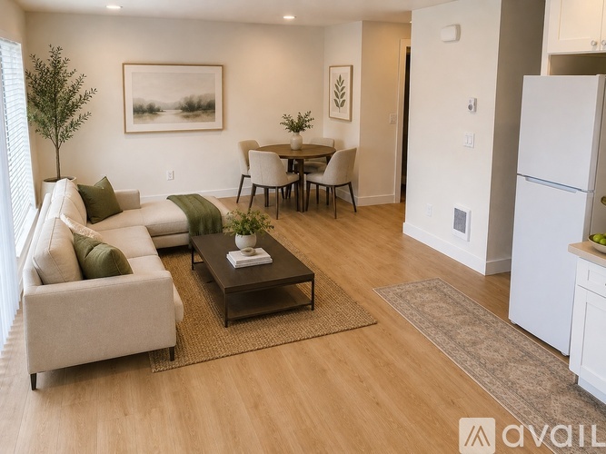 A living room with a couch, a coffee table, and a dining table with chairs.