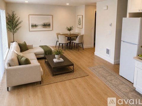 A living room with a couch, a coffee table, and a dining table with chairs.