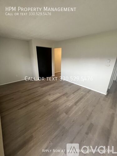 A room with wood flooring and a doorway leading to another room.