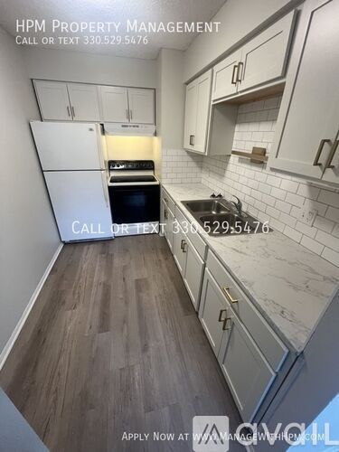 A kitchen with white cabinets and a wooden floor.