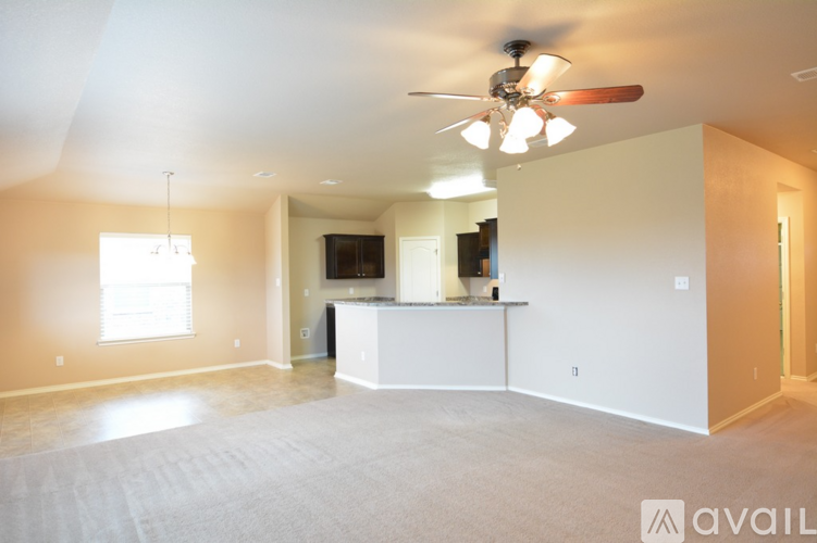 A spacious living room with a ceiling fan and a cabinet.