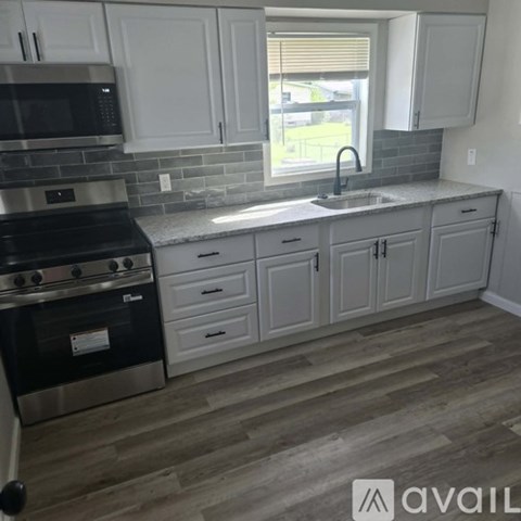 A kitchen with white cabinets and a black stove top oven.