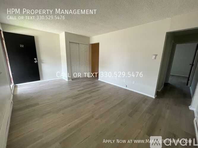 A room with wooden flooring and a door labeled 22 is for sale.